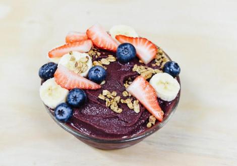 Acai Bowl topped with sliced bananas, strawberries, and blueberries.