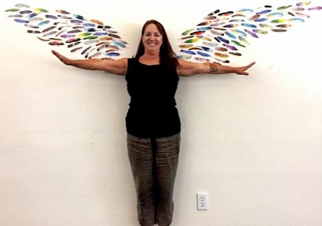 A staff member experiences the art of play and magic through wall art 'wings'.